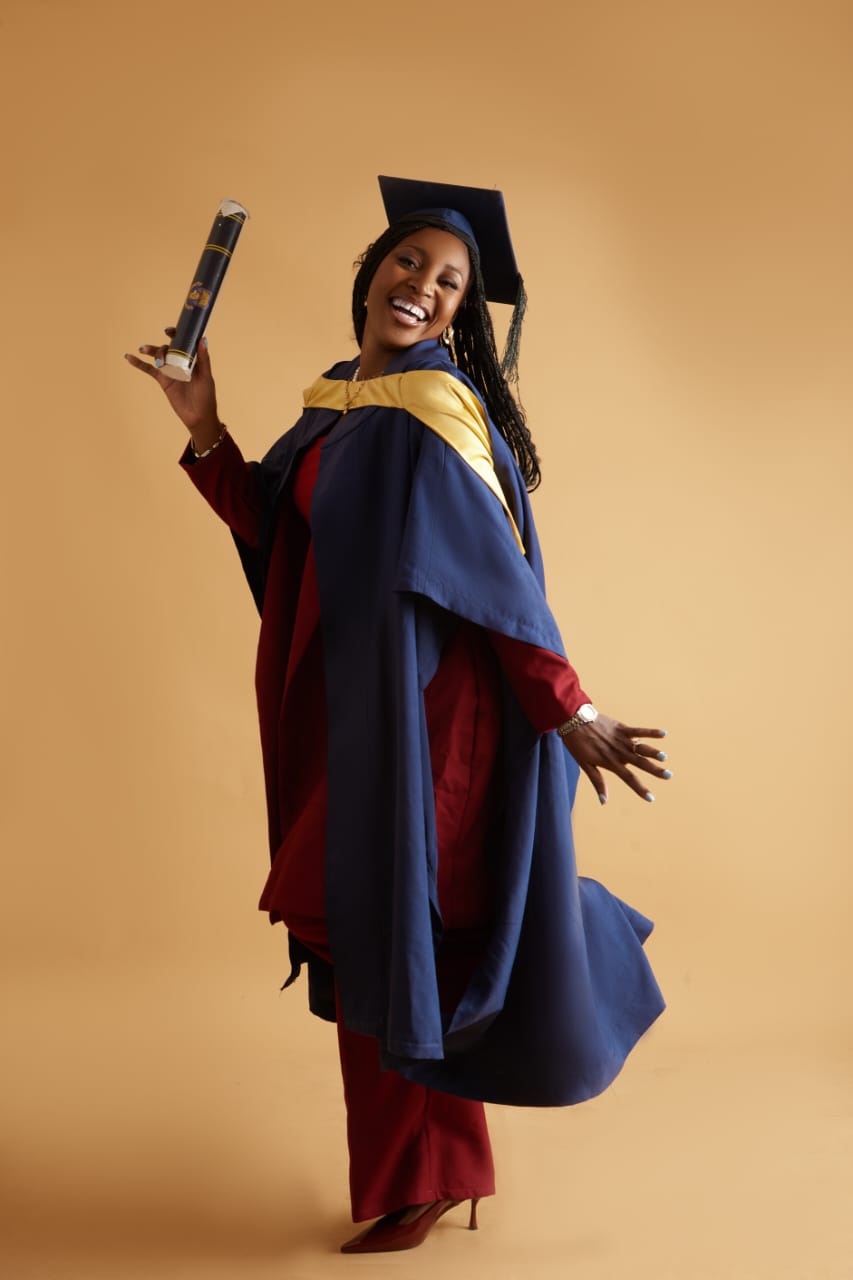 Priscilla celebrating in her graduation gown